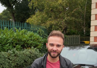 Jack P Shepherd sitting on the bonnet of his American Mustang sports car with his new hair after his hair transplant